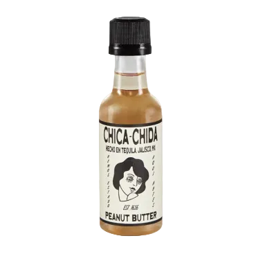 A small bottle of Chic-a-Chida Peanut Butter hot sauce with a black cap and a cream-colored label featuring a black-and-white illustration of a woman's face.